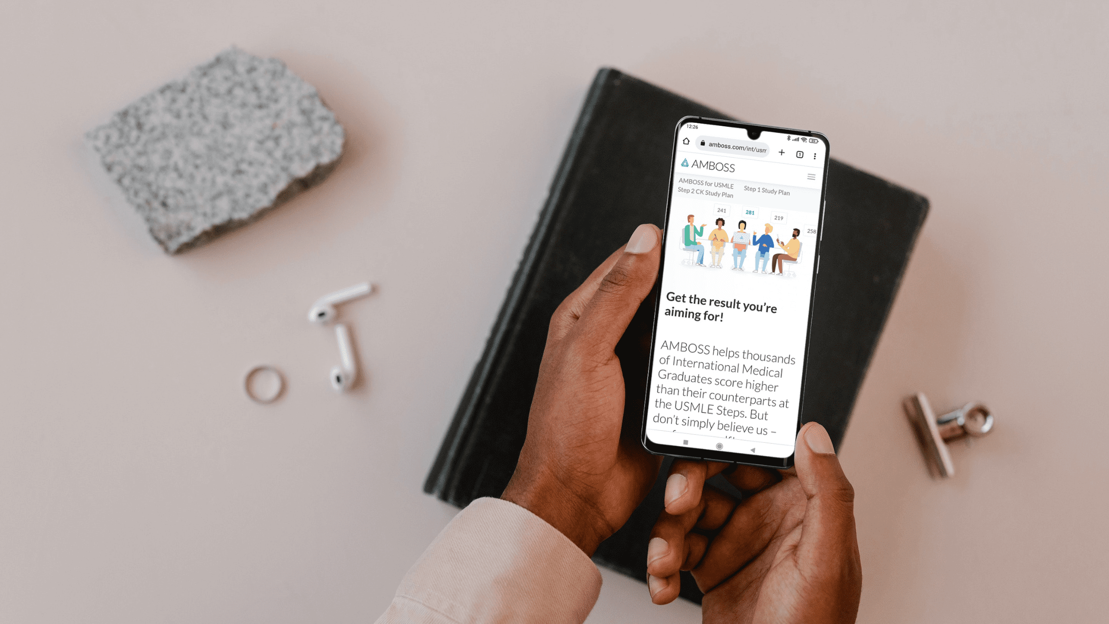 A medical school student looking at the AMBOSS website on their phone for USMLE review.